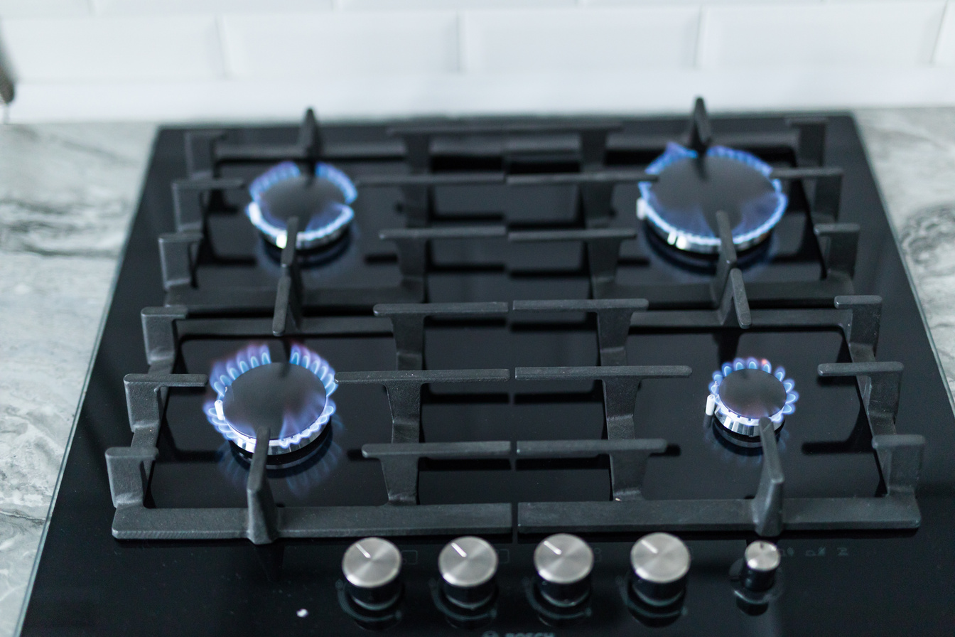 Cooktop with burning gas ring. Gas cooker with blue flames.